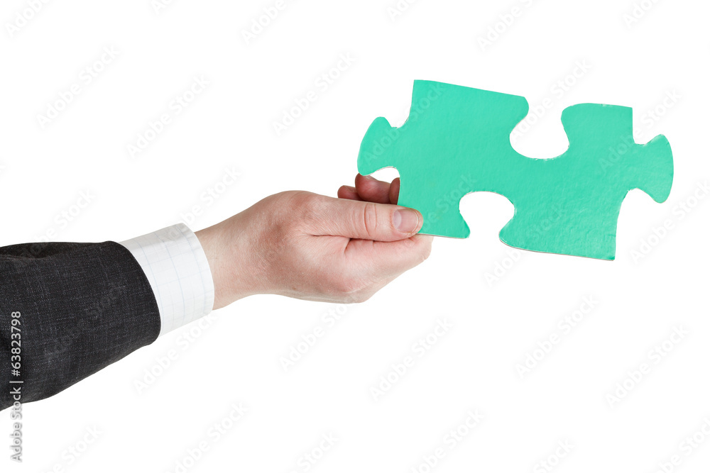 male hand holding big green paper puzzle piece male hand holding big green paper puzzle piece