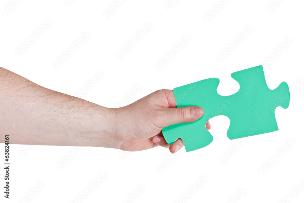 male hand holding big green paper puzzle piece male hand holding big green paper puzzle piece