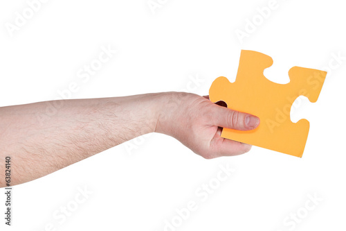 male hand holding big yellow paper puzzle piece