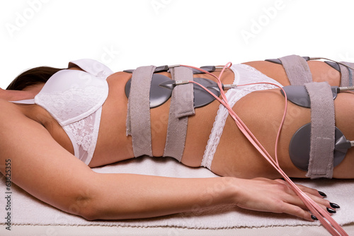 Electrodes on young woman's body at the spa.