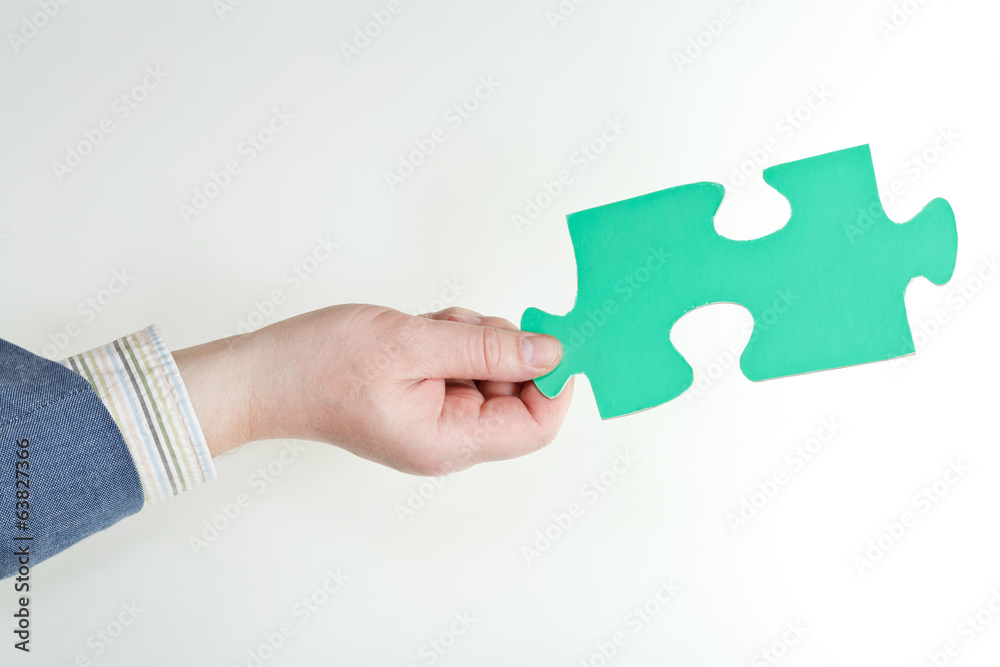 green puzzle piece in male hand green puzzle piece in male hand
