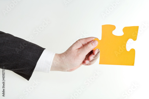 yellow puzzle piece in male hand