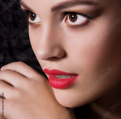 Portrait of beautiful young woman with jewelry on black