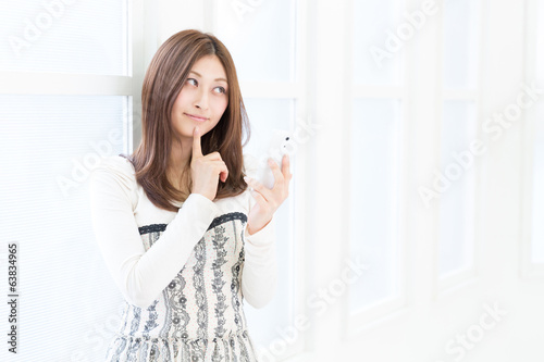 Free Download 部屋でスマートフォンを見る女性 - GFXLoad