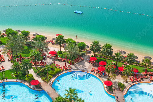 Photography Tropical scenery of red parasols at Arabian Sea, UAE