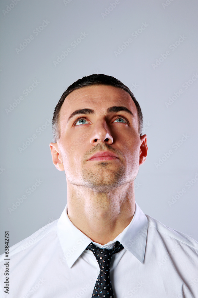 Portrait of a man looking up at copyspace over gray background Portrait of a man looking up at copyspace over gray background