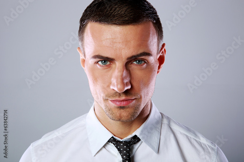 Portrait of a confident businessman over gray background