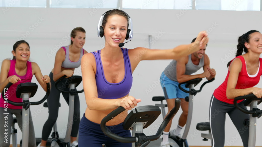 Spinning class in fitness studio led by energetic instructor Spinning class in fitness studio led by energetic instructor