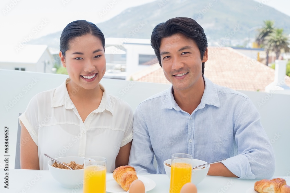 Smiling couple having breakfast together Smiling couple having breakfast together