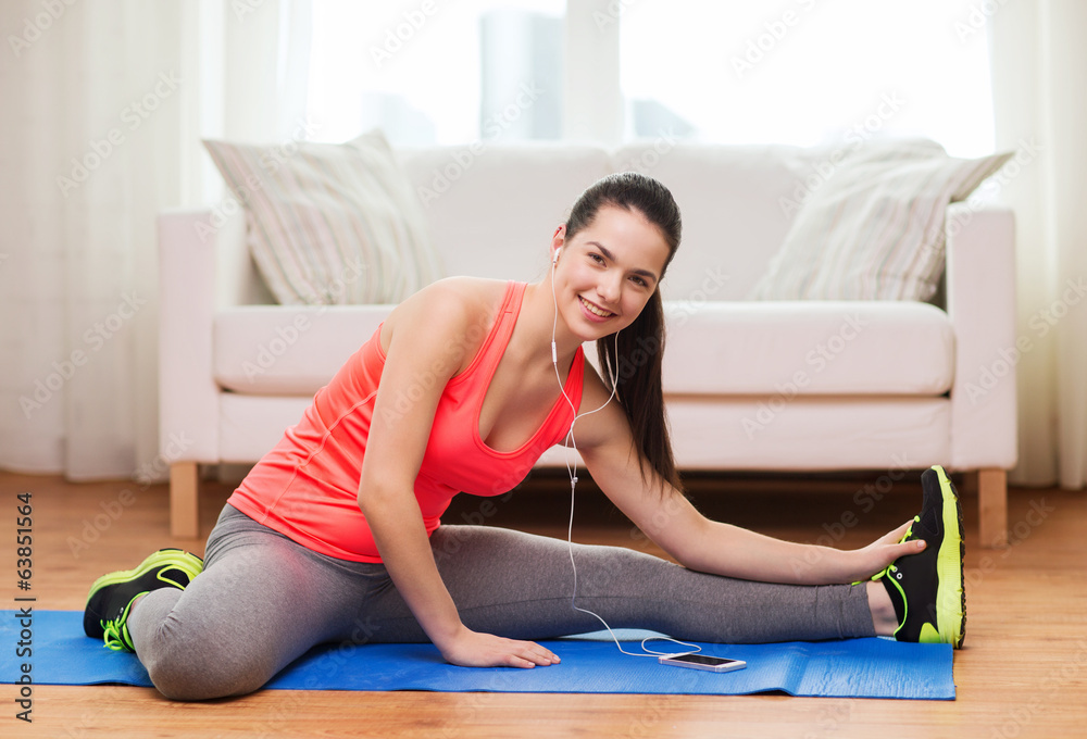 smiling teenage girl streching on floor at home