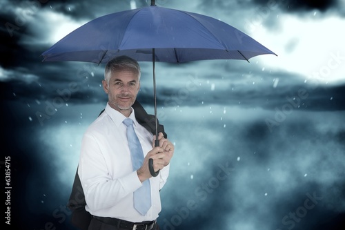 Composite image of businessman holding blue umbrella © WavebreakMediaMicro