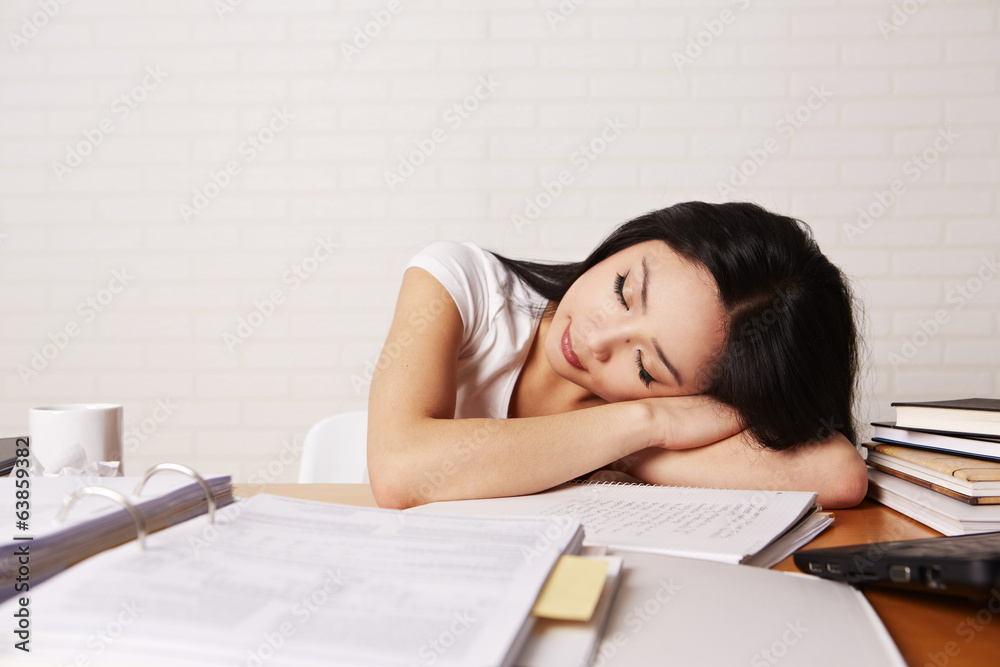 Studentin am Schreibtisch beim schlafen Studentin am Schreibtisch beim schlafen