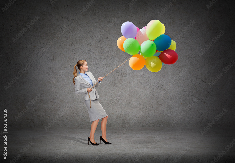 smiling businesswoman pulling rope with balloons smiling businesswoman pulling rope with balloons