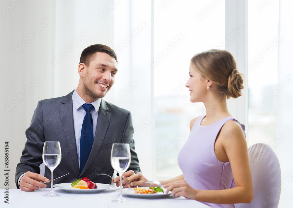 smiling couple eating main course at restaurant