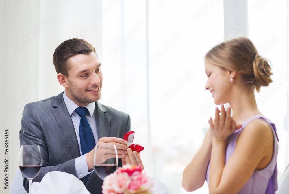 man proposing to his girlfriend at restaurant man proposing to his girlfriend at restaurant