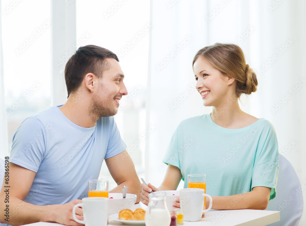 smiling couple having breakfast at home