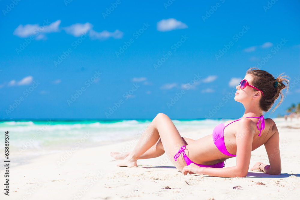 front view of long haired young woman in bikini lying on front view of long haired young woman in bikini lying on