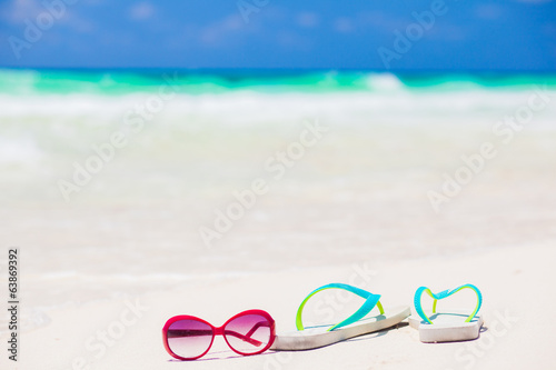 flip flops and sunglasses on tropical beach with waves on