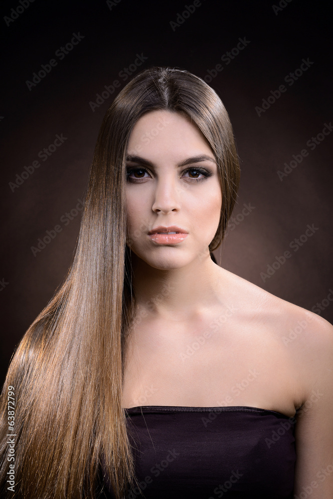Beautiful young woman with long hair on dark brown background Beautiful young woman with long hair on dark brown background