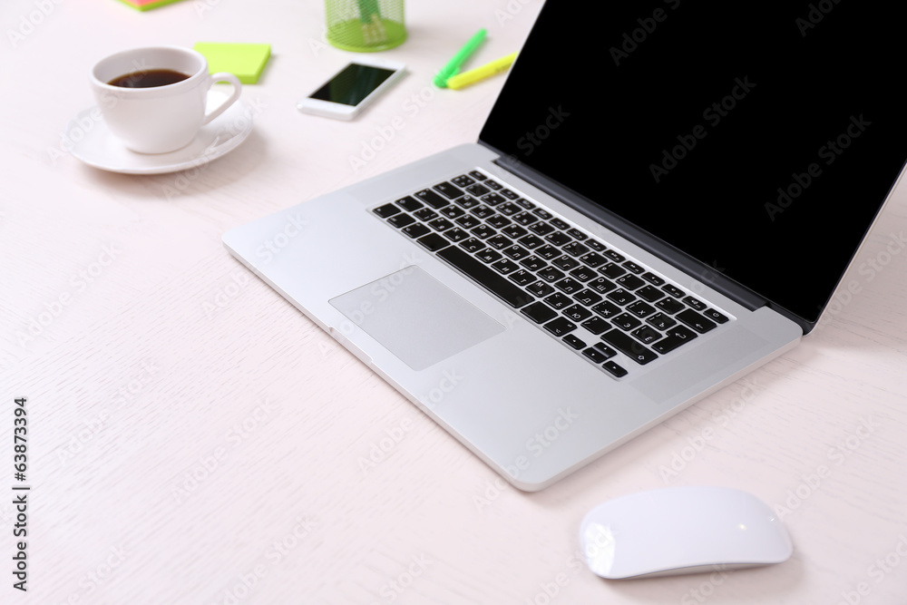 Office workplace with open laptop on wooden desk Office workplace with open laptop on wooden desk