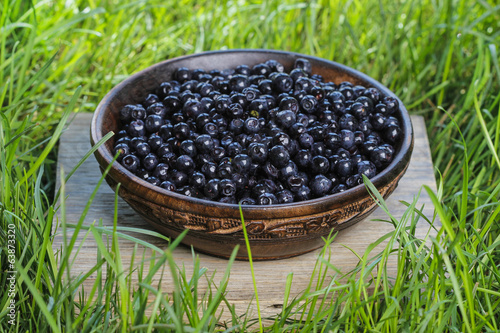 Wooden bowl of fresh blueberries. Selective focus