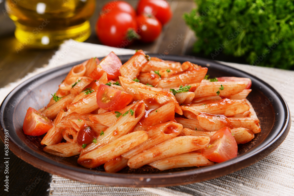 Pasta with tomato sauce on plate on table close-up Pasta with tomato sauce on plate on table close-up