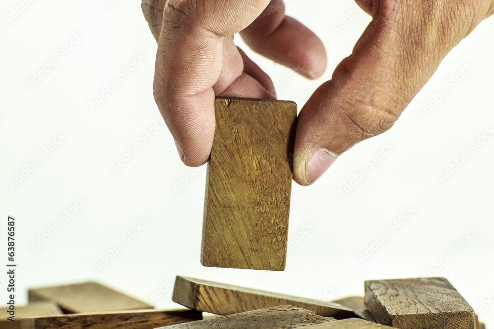 Obraz premium Hand picking up wood domino