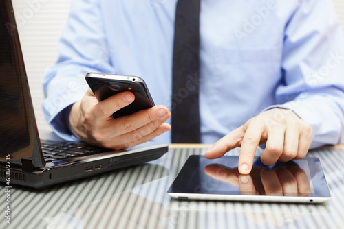 businessman is working on tablet and using smart phone in office