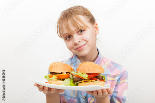 Fotografia Little smiling blond girl with homemade hamburgers on white plat