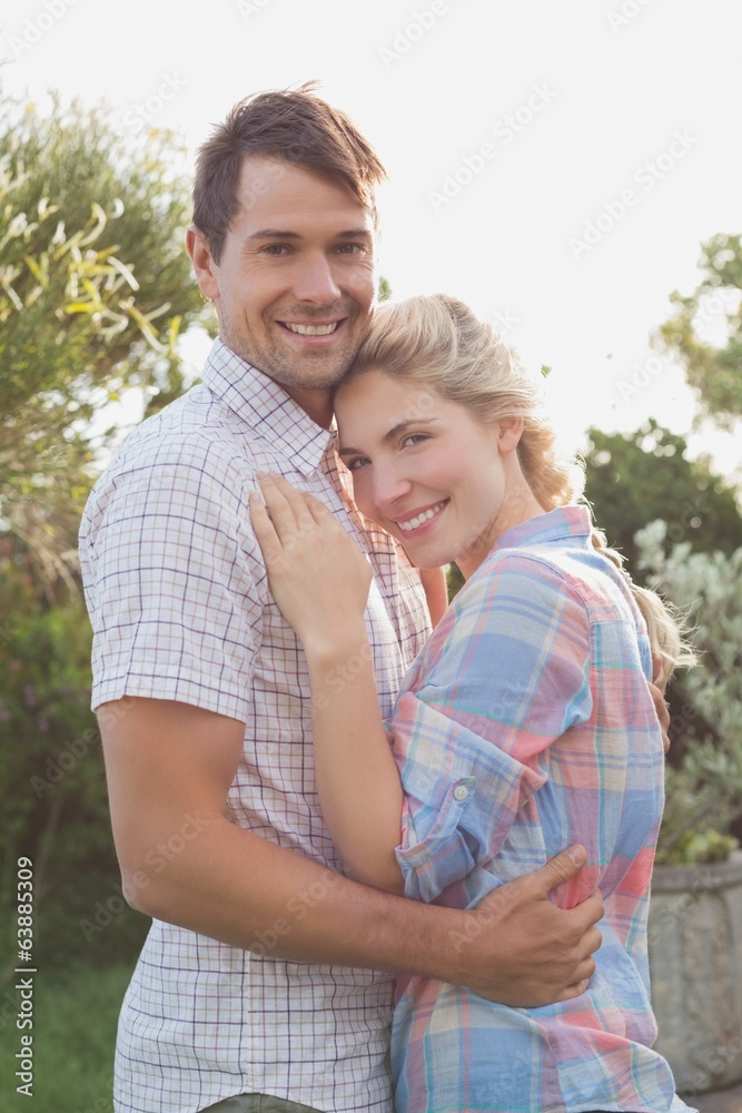 Smiling young couple embracing in the park Smiling young couple embracing in the park