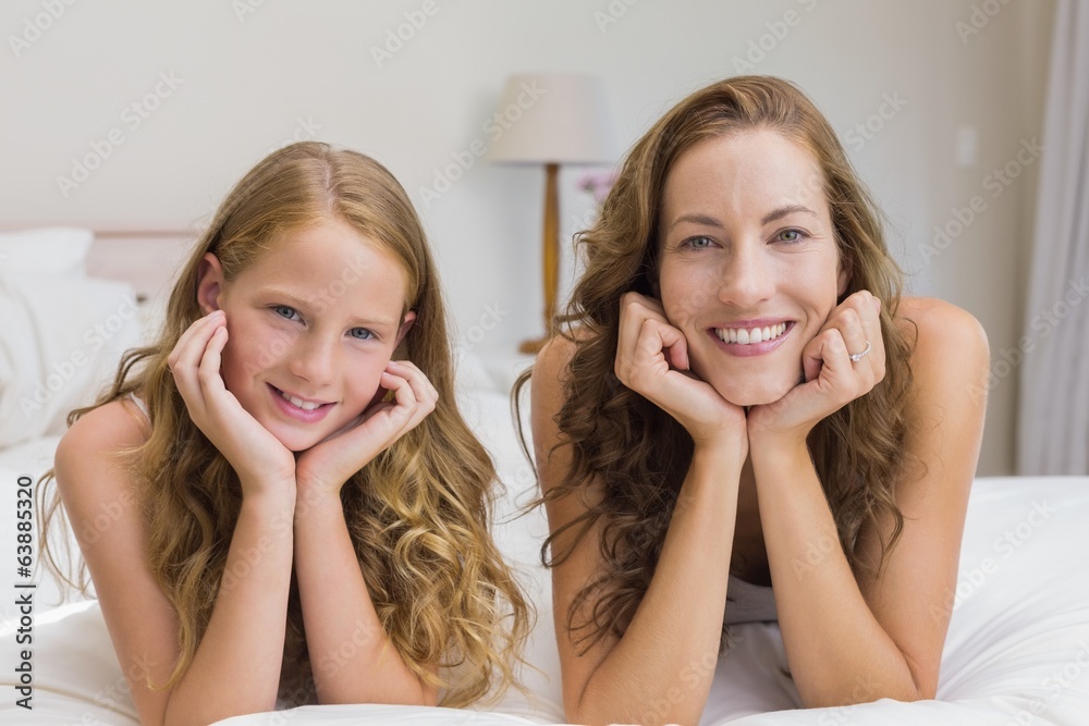Smiling mother and daughter lying in bed Smiling mother and daughter lying in bed