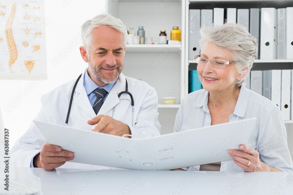 Doctor with female patient reading reports Doctor with female patient reading reports