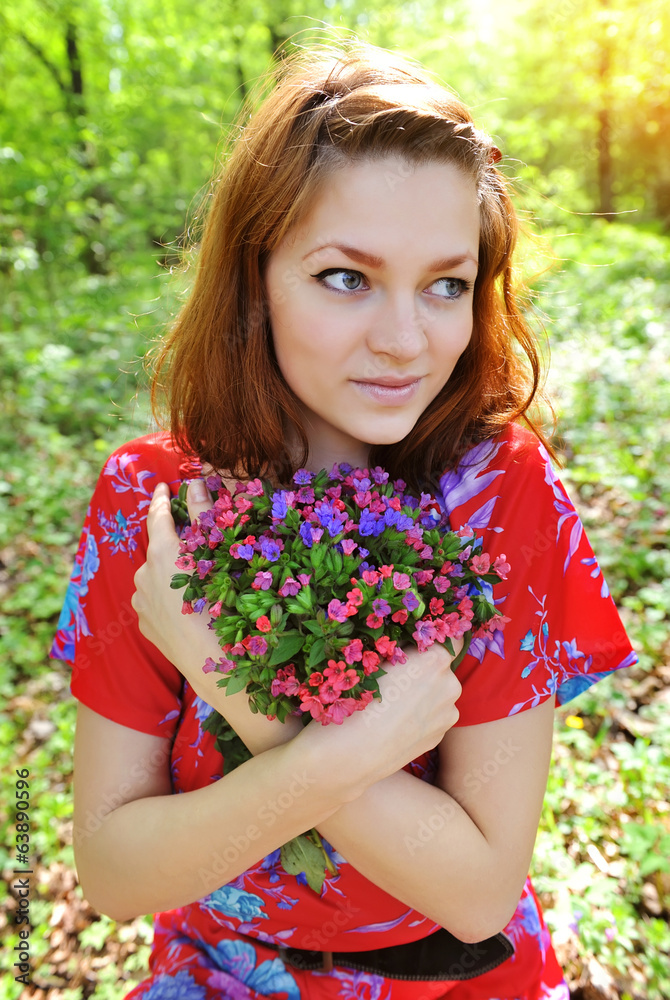 Beautiful young woman with the bouquet of spring flowers Beautiful young woman with the bouquet of spring flowers