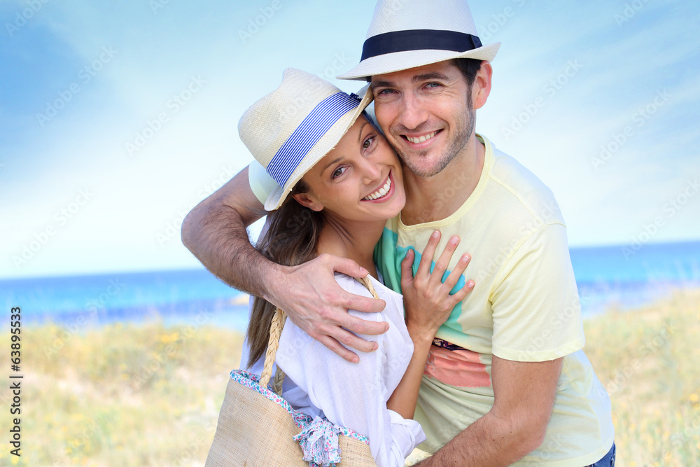 Portrait of sweet couple embracing by the beach