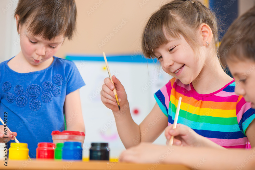 Cute children drawing with colorful paints at kindergarten Cute children drawing with colorful paints at kindergarten