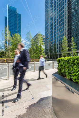 Businessmen walking outside of modern office buildings