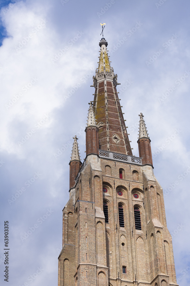 Brickwork tower against cloudy sky Bruges
