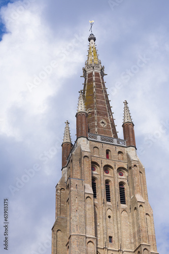 Brickwork tower against cloudy sky Bruges