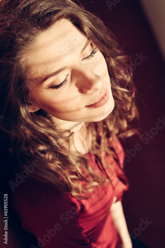 fashion curly young woman basking in the sun