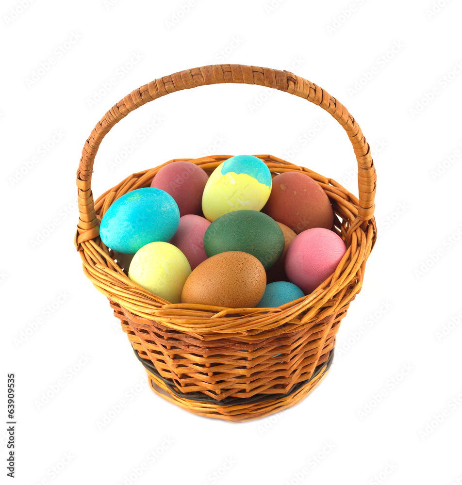 Color Easter eggs in brown wicker basket isolated Color Easter eggs in brown wicker basket isolated