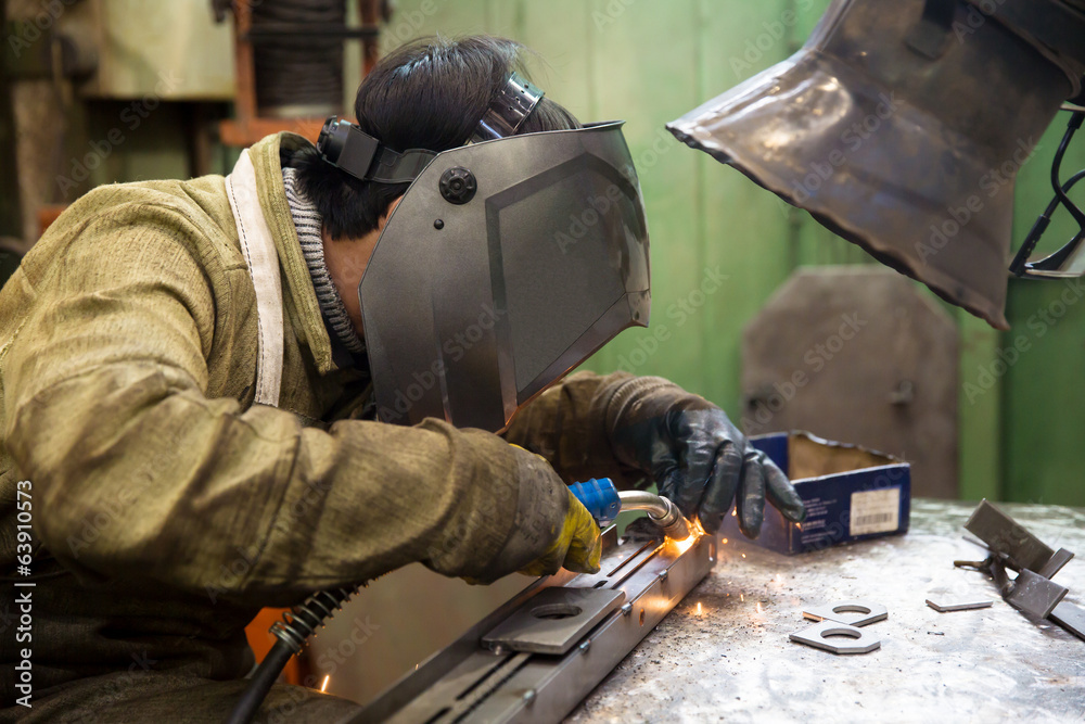 Fototapeta premium Industrial Worker Welder Welding Metal at Factory Workshop