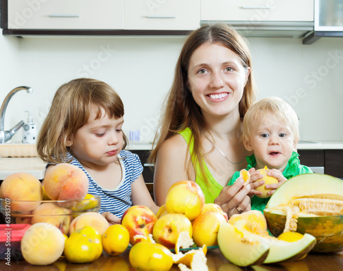  mother with children eating melon and other fruits photo