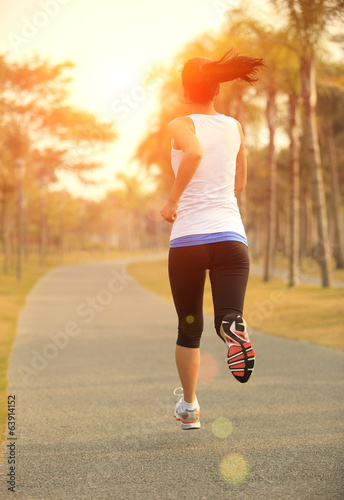 young fitness woman runner athlete running at tropical park