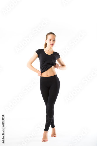 Young sexy athletic woman in black sportswear full-length - isol