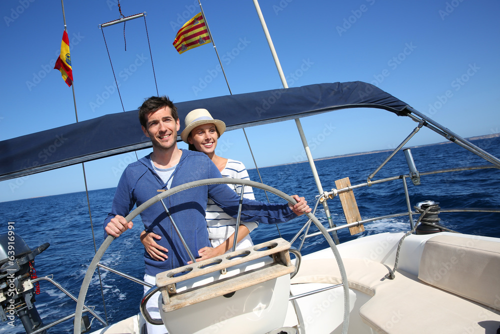 Happy couple enjoying journey on sailboat