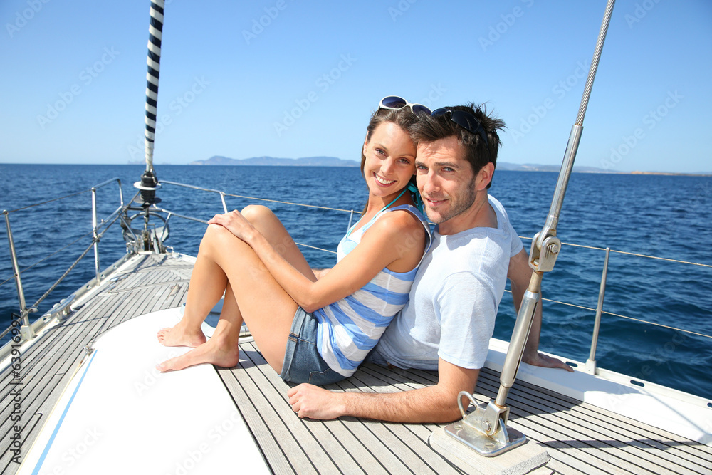 Happy couple navigating on sailboat