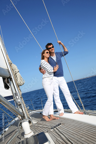 Fancy couple enjoying sailing on a beautiful sailboat