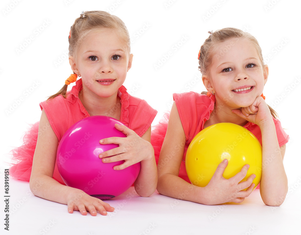 Two charming sisters love to play ball. Two charming sisters love to play ball.