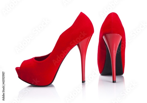 Female red high-heeled shoes over white background.