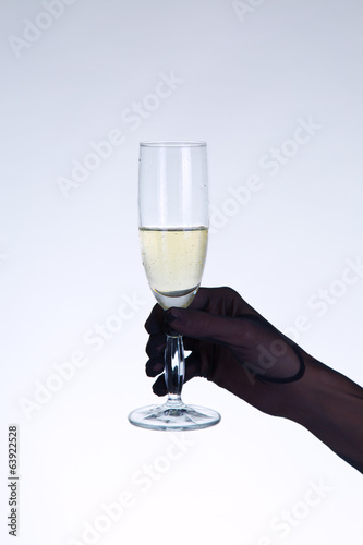 Female hand in black opera glove holding champagne glass